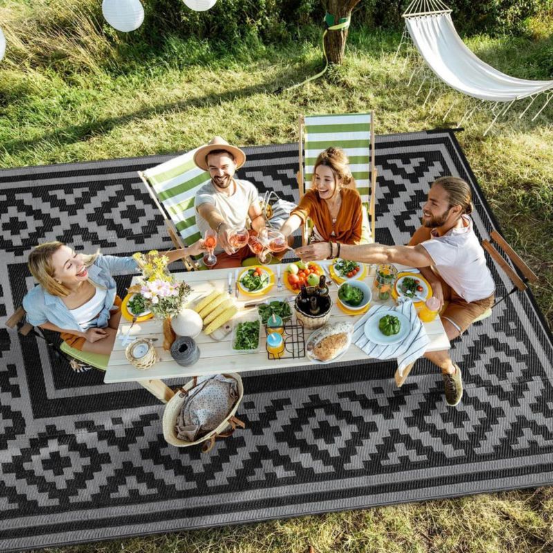Alfombra exterior Kalafun 122 × 183 cm de plástico con franjas negras reversibles