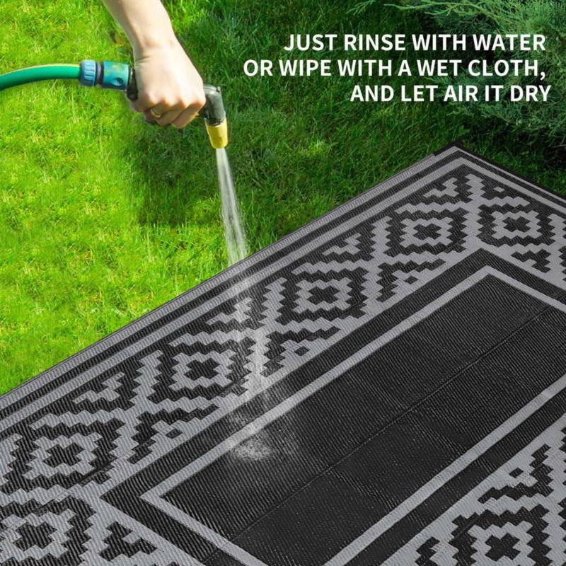 Alfombra exterior Kalafun 122 × 183 cm de plástico con franjas negras reversibles