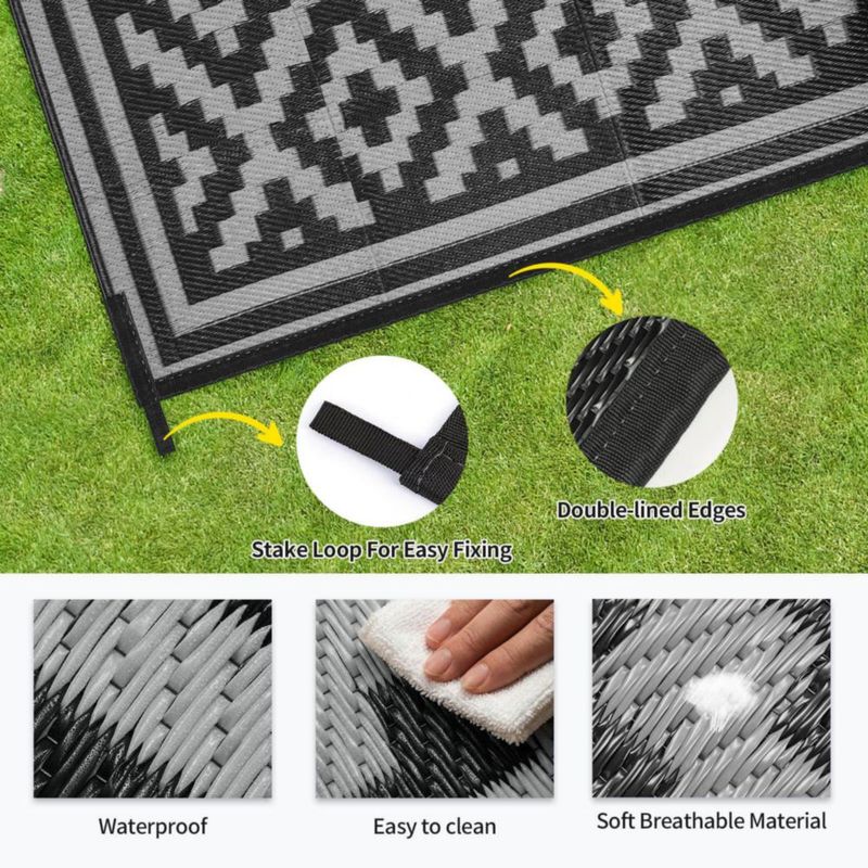 Alfombra exterior Kalafun 122 × 183 cm de plástico con franjas negras reversibles