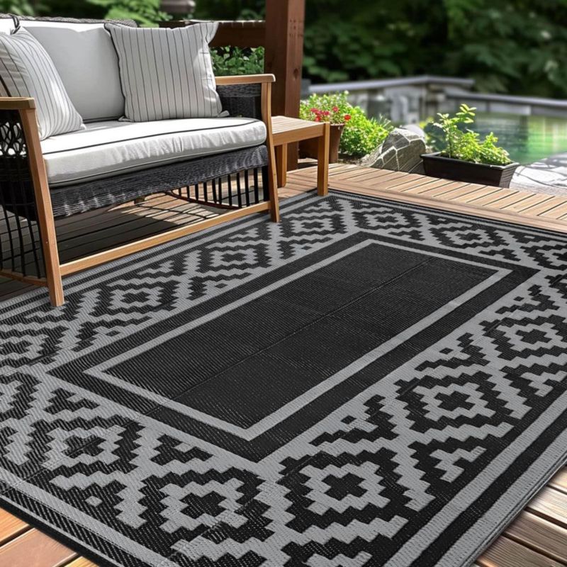 Alfombra exterior Kalafun 122 × 183 cm de plástico con franjas negras reversibles